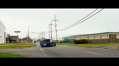 a car driving down a street next to a building