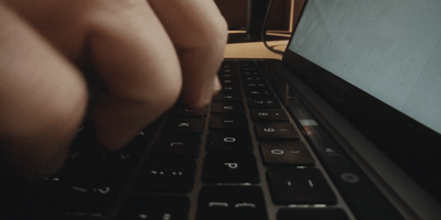 a close up of a person typing on a laptop