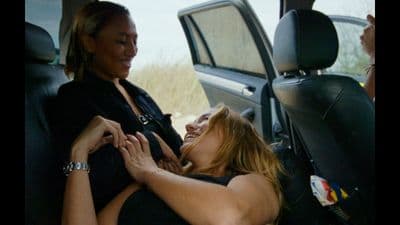 two women sitting in the back seat of a car