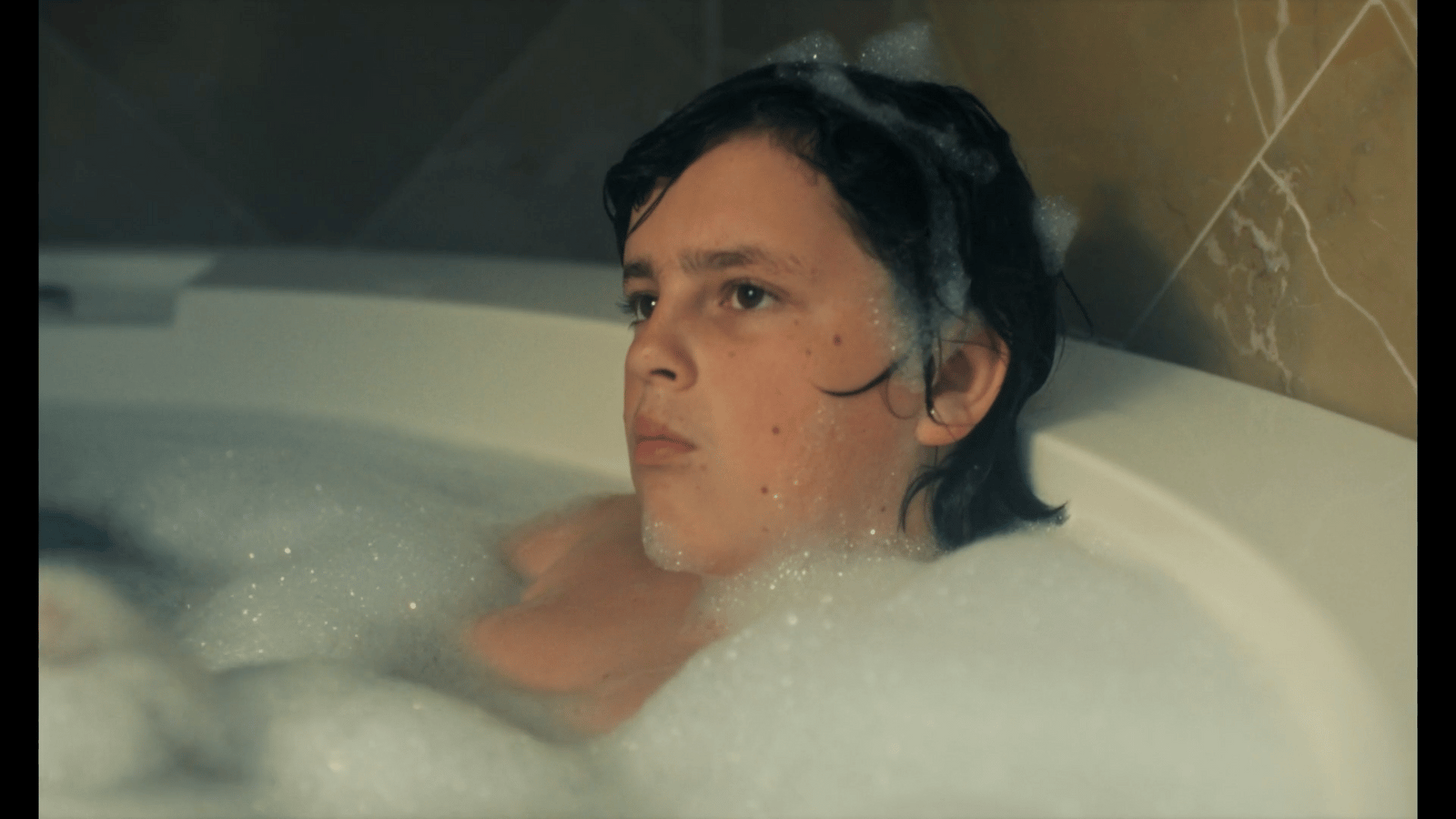 a woman in a bathtub with bubbles of water