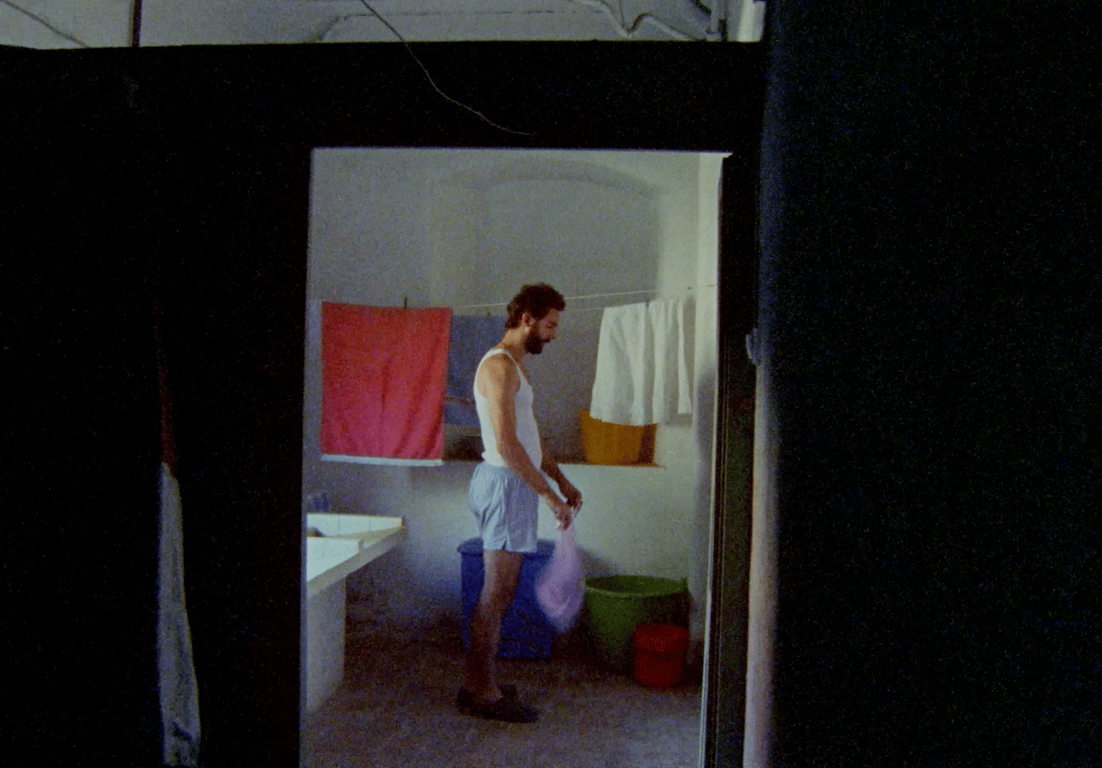 a man standing in a bathroom holding a bag