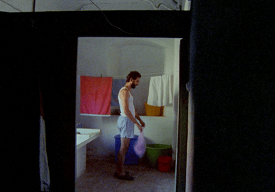 a man standing in a bathroom holding a bag