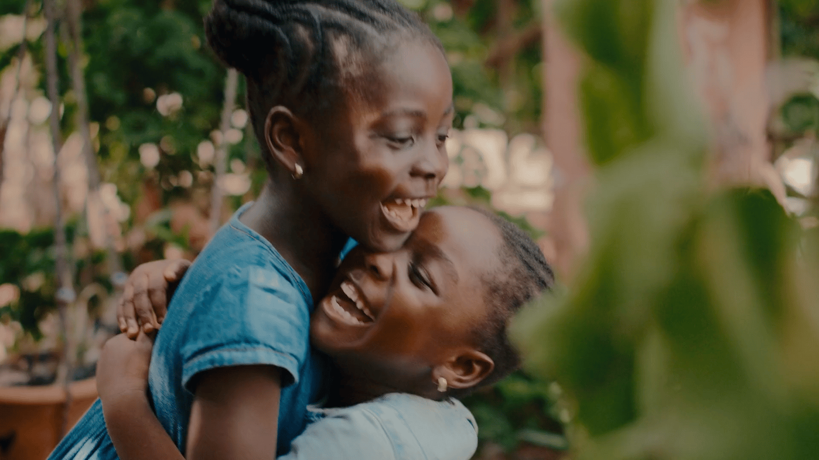a woman hugging another woman in a garden