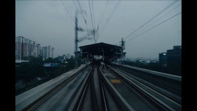 a train traveling down train tracks next to a tall building
