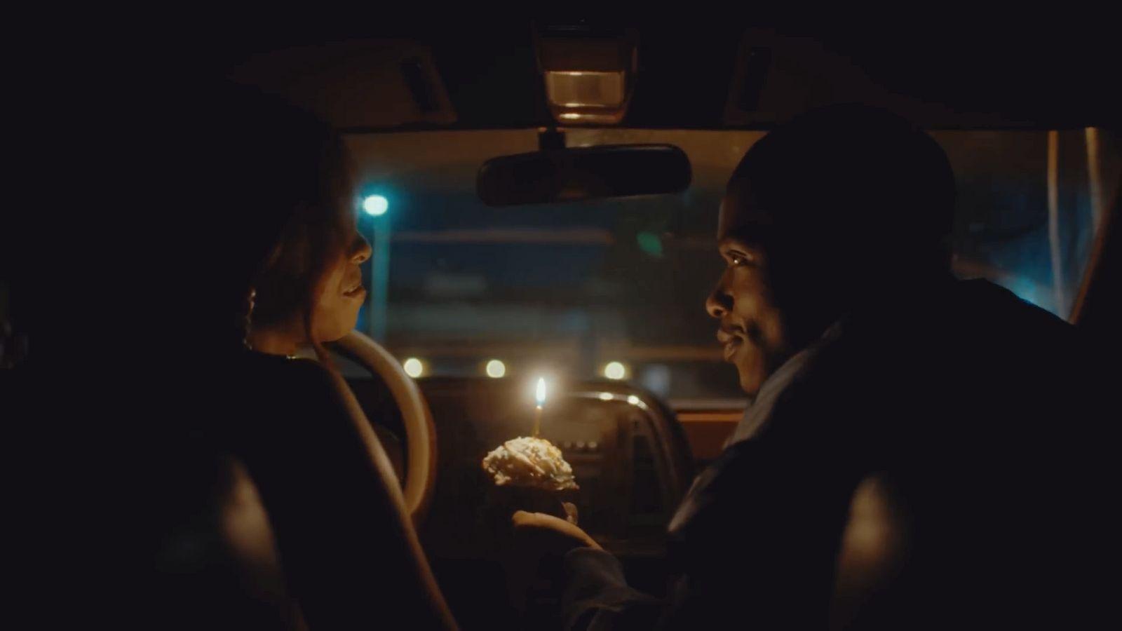 a man and a woman sitting in a car at night