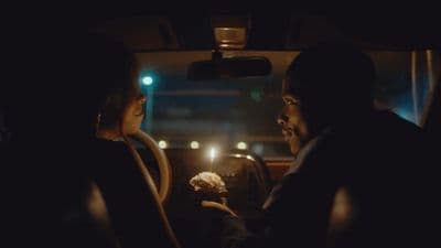 a man and a woman sitting in a car at night