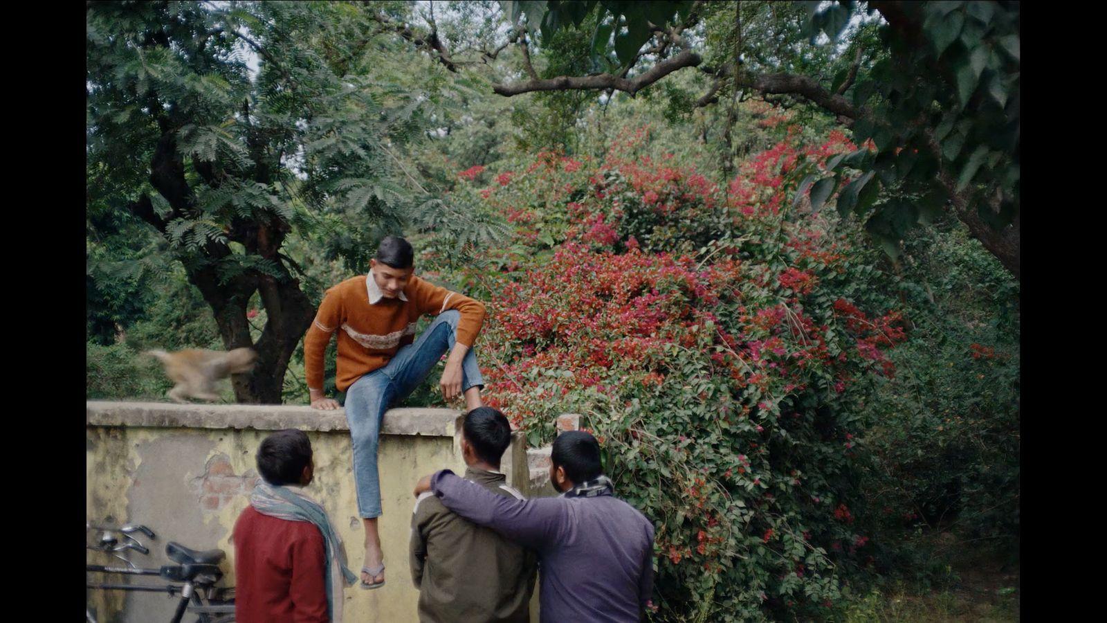 a man sitting on top of a wall next to a group of people