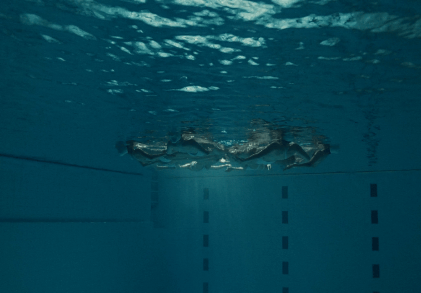 a person swimming in a pool with a surfboard