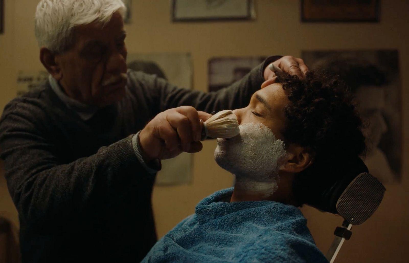 a man is shaving his face with a razor