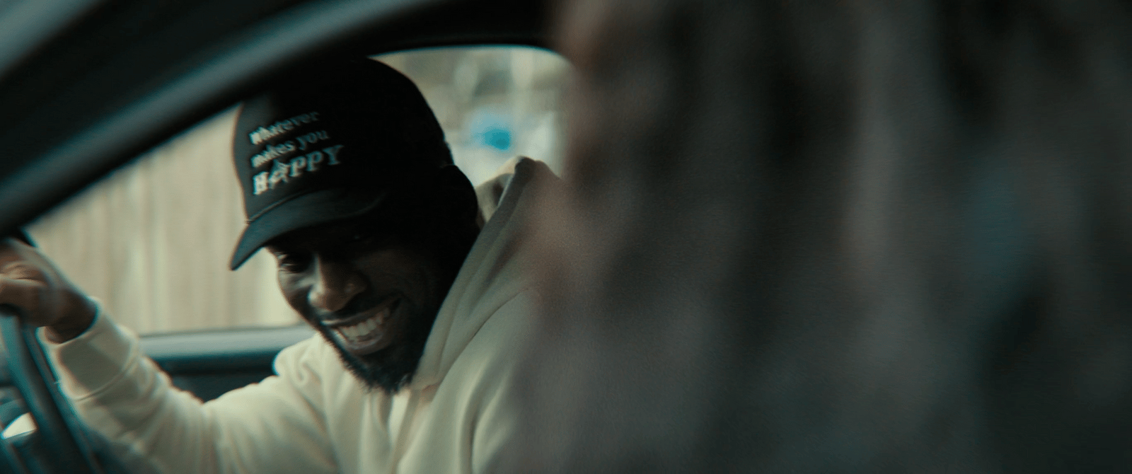 a man wearing a hat sitting in a car