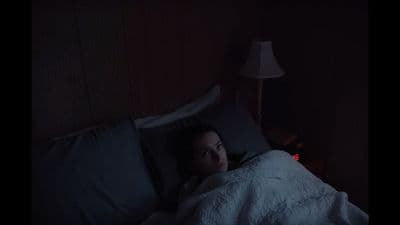 a woman laying in bed under a blanket