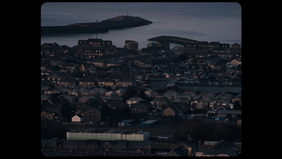a view of a city at night with a body of water in the distance