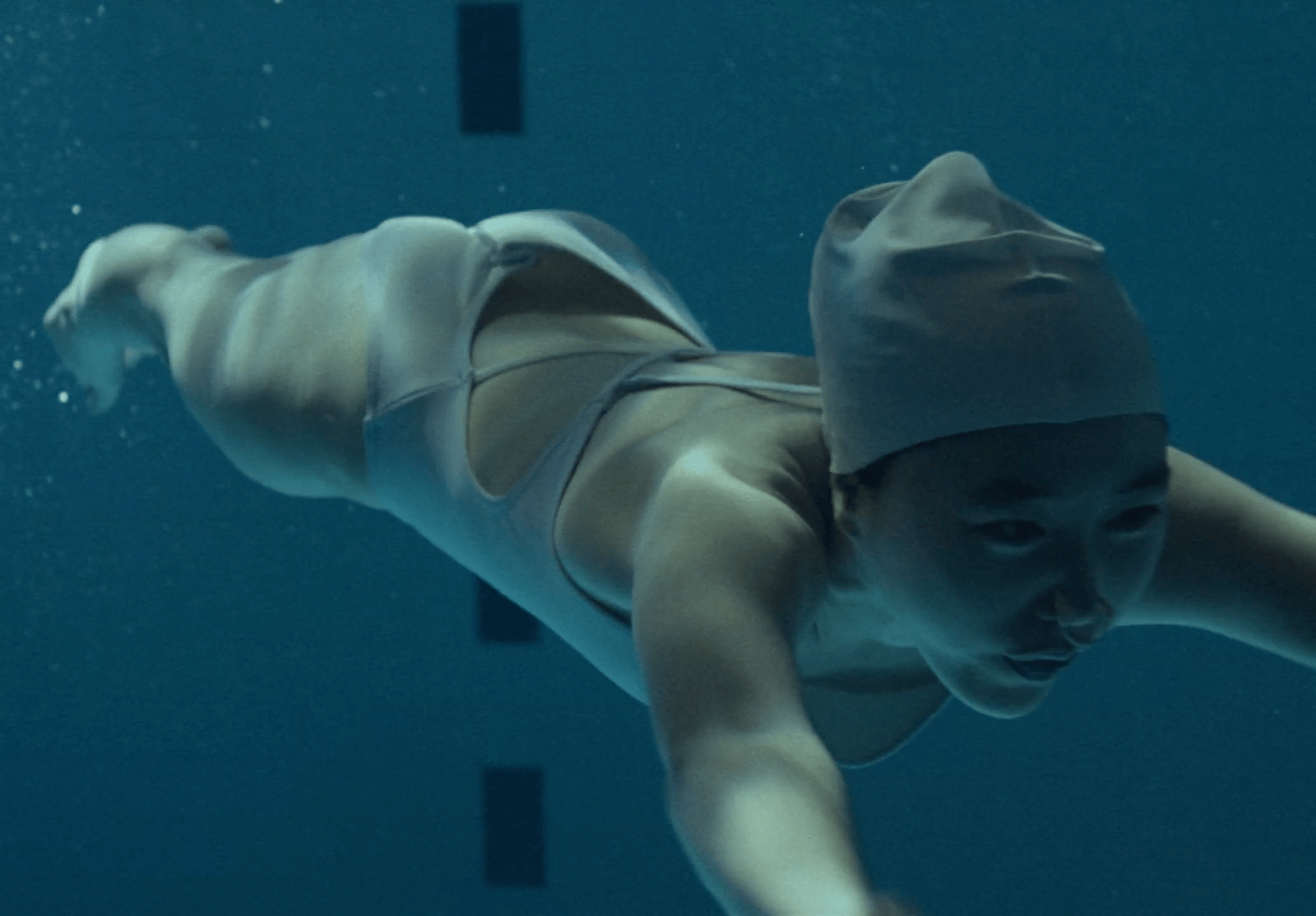 a woman in a hat swimming in a pool
