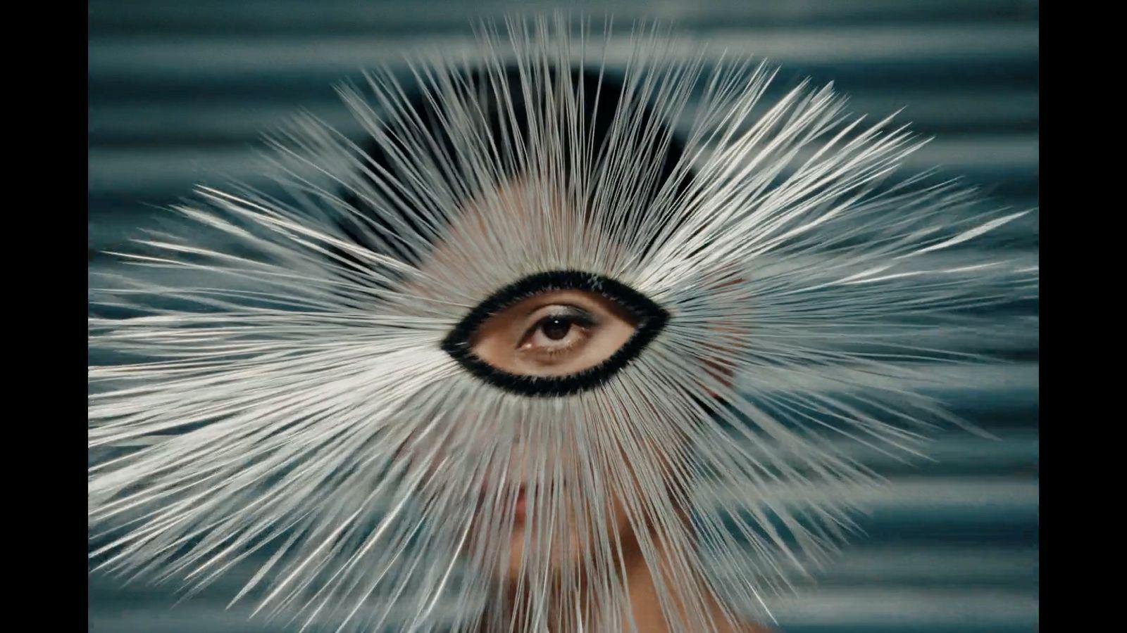 a woman's face with white hair and an eye in the center