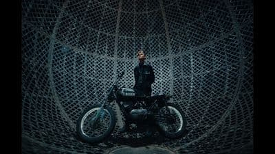 a man standing next to a motorcycle in a cage