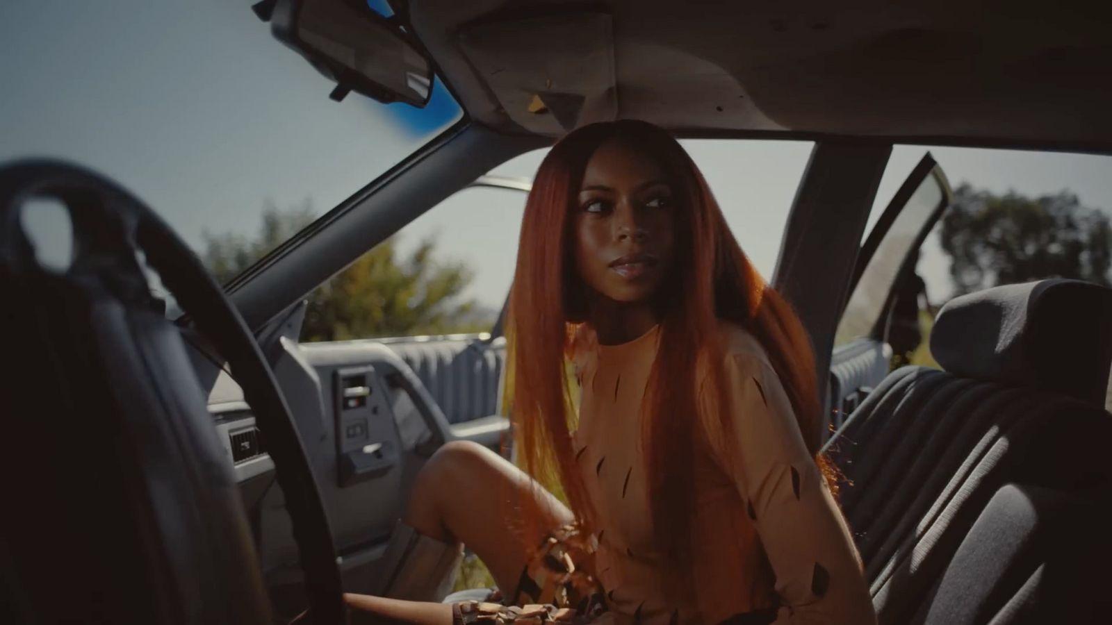 a woman with orange hair sitting in a car