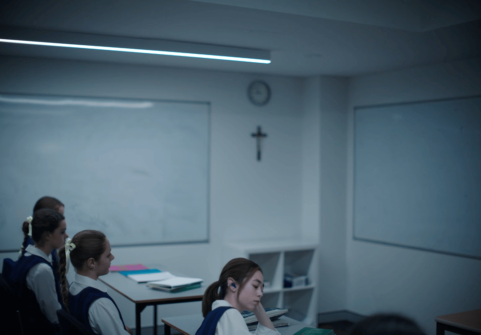 a group of girls sitting at desks in a classroom