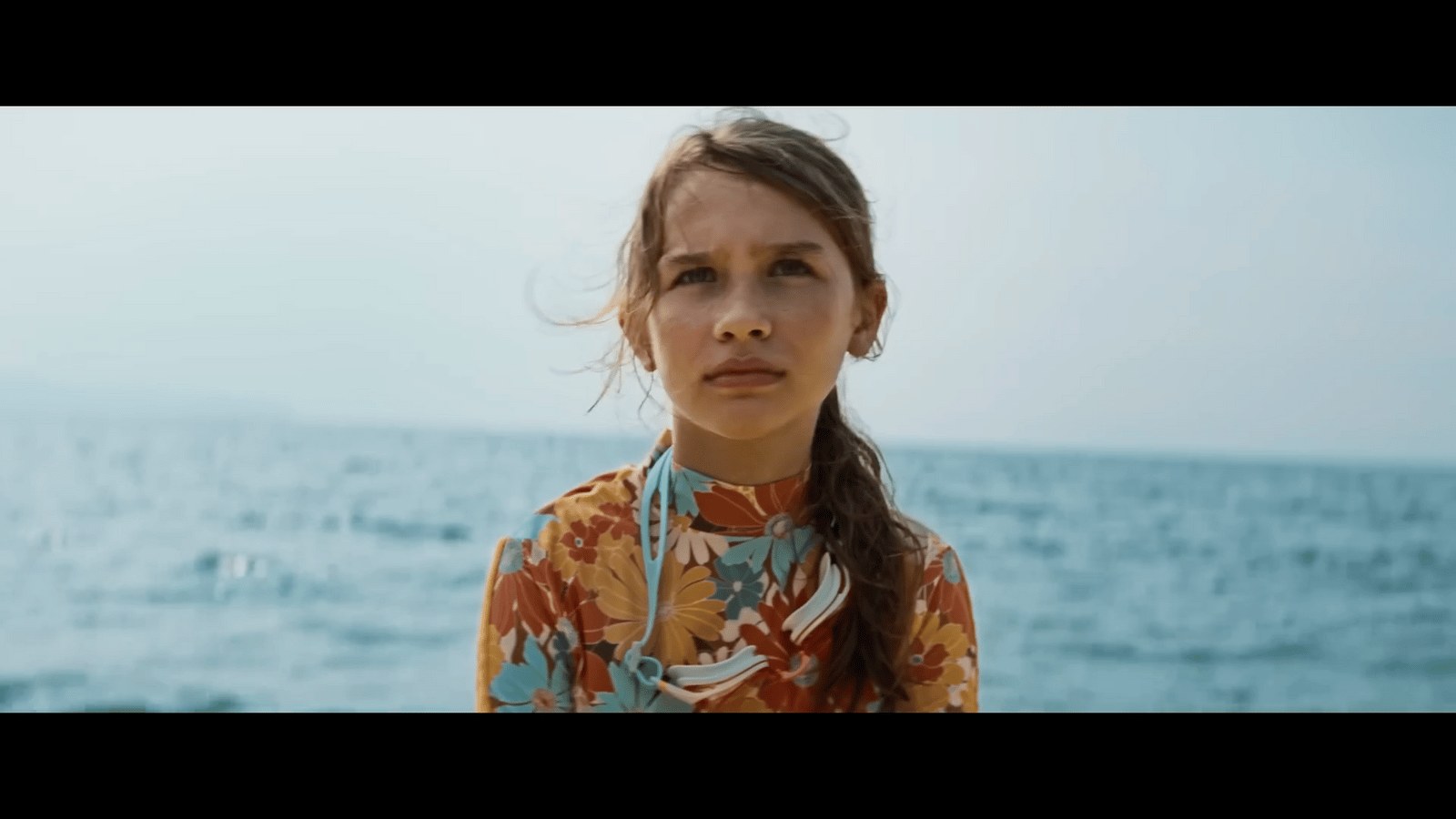 a woman standing in front of a body of water