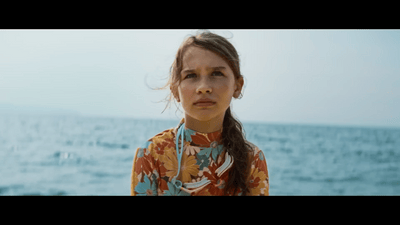a woman standing in front of a body of water