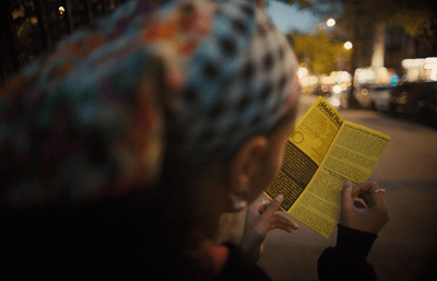 a woman reading a book on the side of the road
