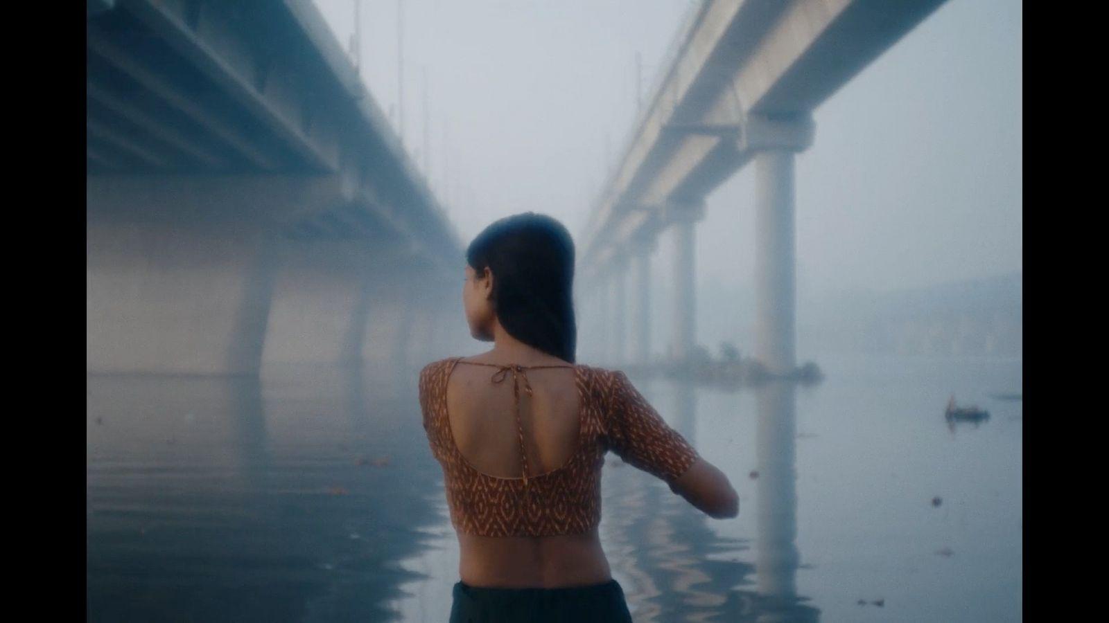a woman standing in front of a bridge on a foggy day