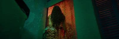 a woman standing in front of a red curtain