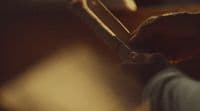 a close up of a person holding a wooden stick