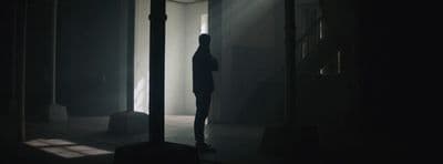 a person standing in a dark room in the dark