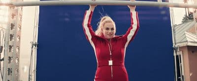 a woman in a red jumpsuit is holding a bar