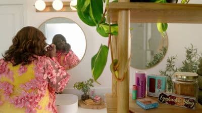 a woman standing in front of a mirror brushing her teeth