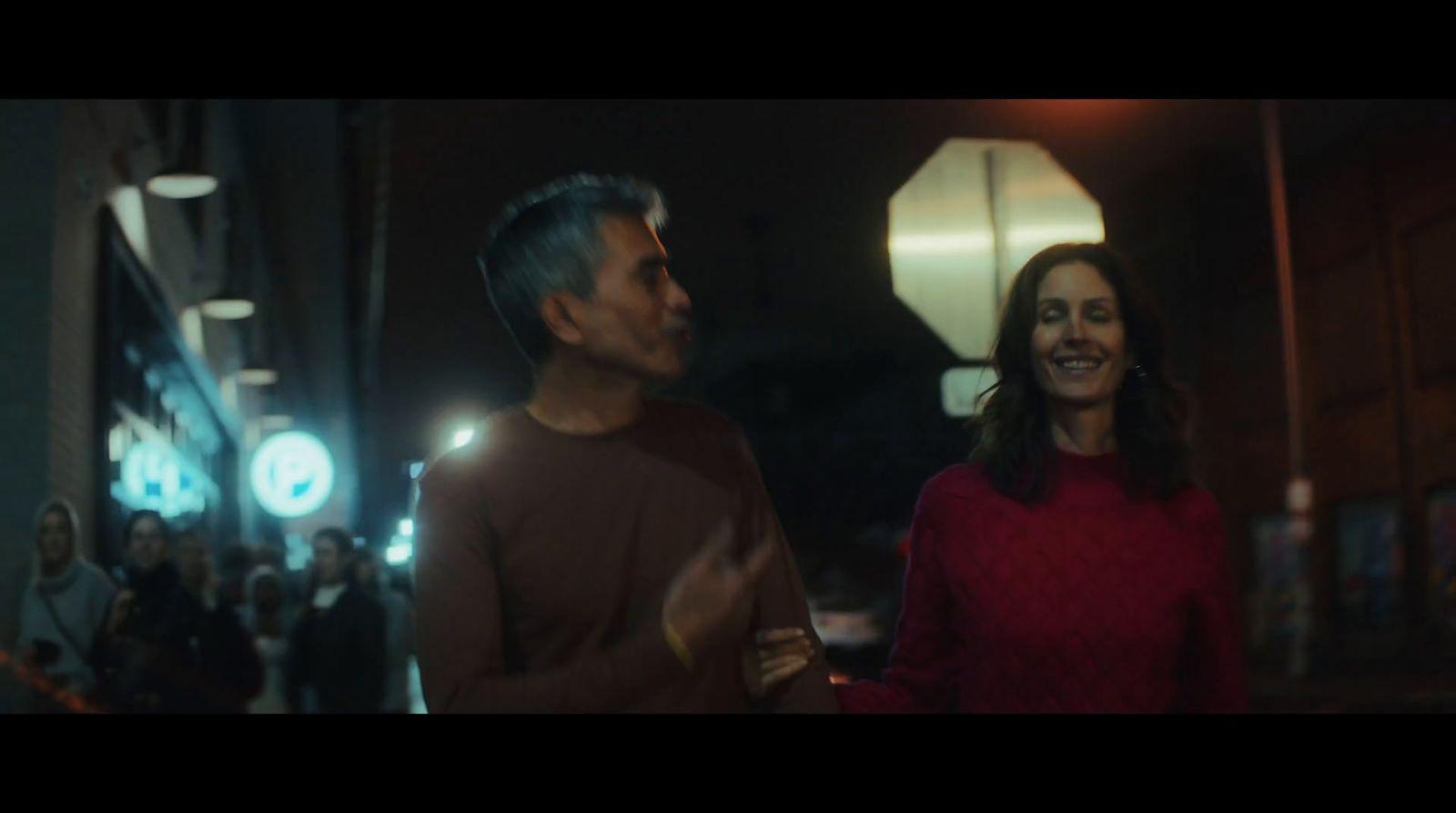 a man standing next to a woman on a street