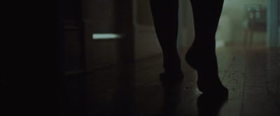 a person walking down a hallway in the dark