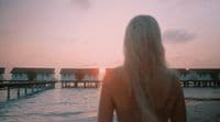 a woman standing in front of a body of water