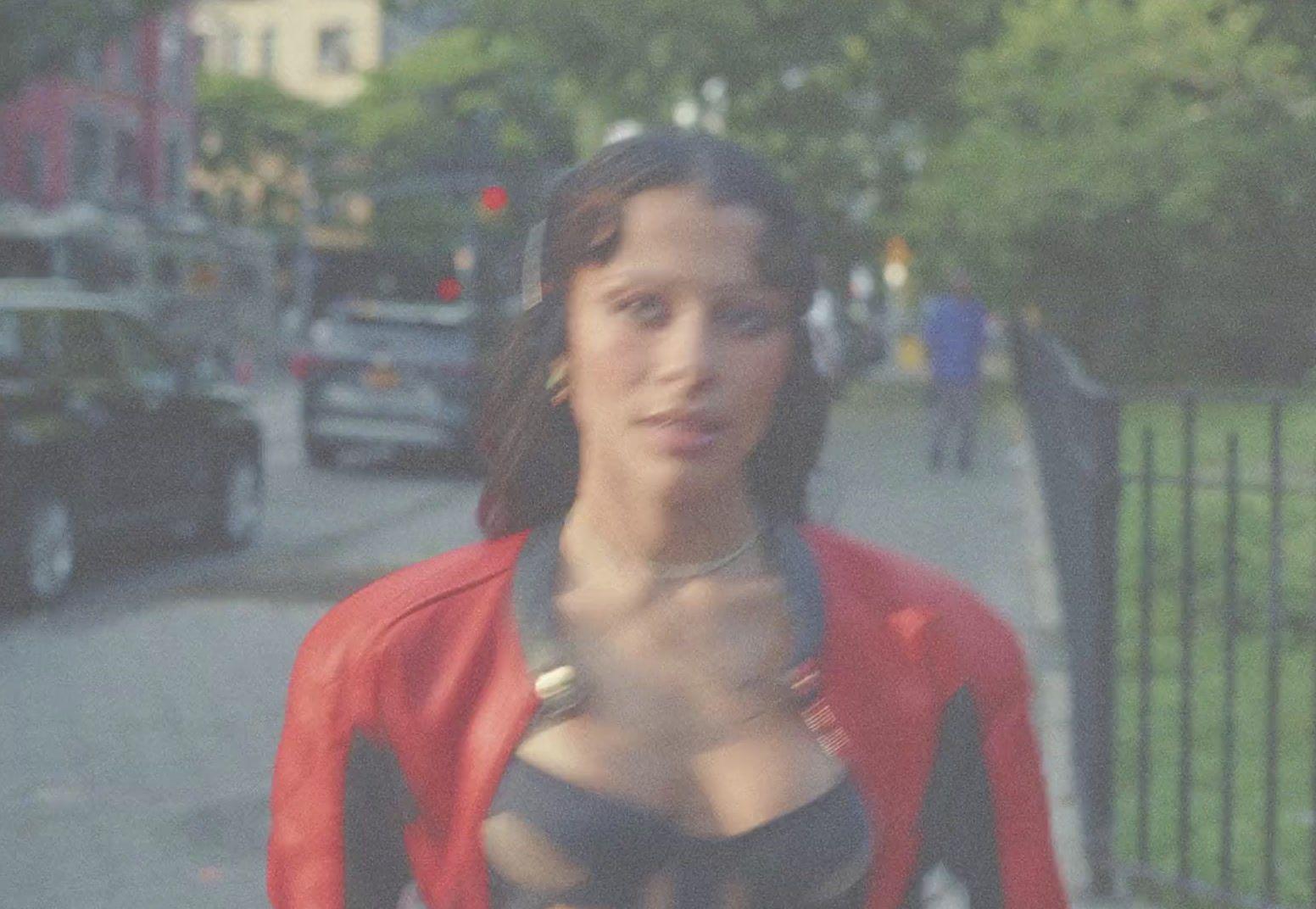a woman in a bra top standing on a sidewalk