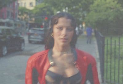a woman in a bra top standing on a sidewalk