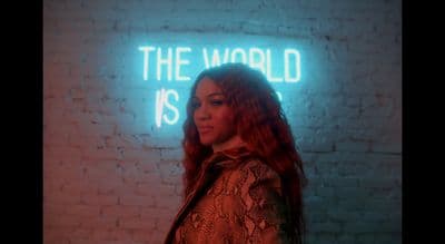 a woman standing in front of a neon sign