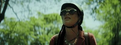 a woman wearing a helmet and goggles in the woods