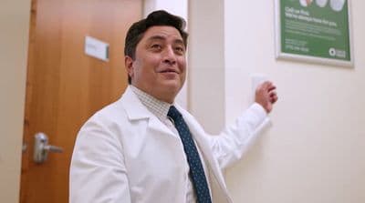 a man in a white lab coat and tie