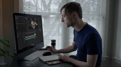 a man sitting in front of a computer monitor