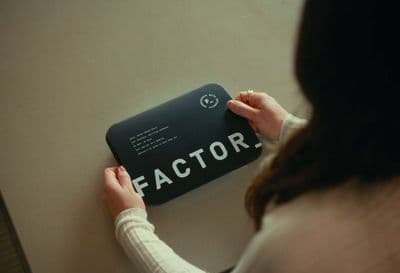 a woman holding a black and white sign that says factory