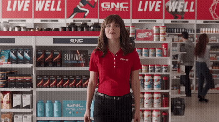 a woman in a red shirt is standing in a store