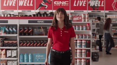a woman in a red shirt is standing in a store