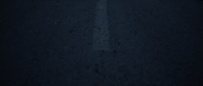 a stop sign on the side of a road at night