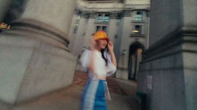 a woman walking down a street talking on a cell phone