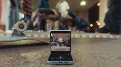 a cell phone sitting on top of a table next to a skateboard