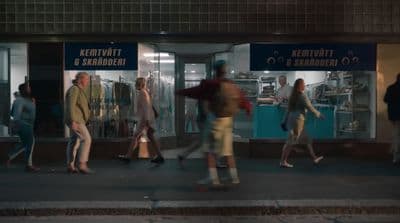 a group of people walking down a street at night