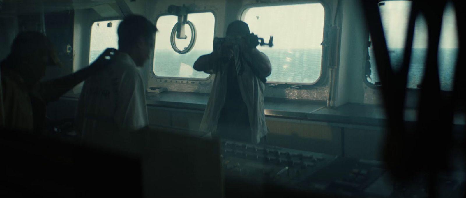 two people standing on a ship looking out the window