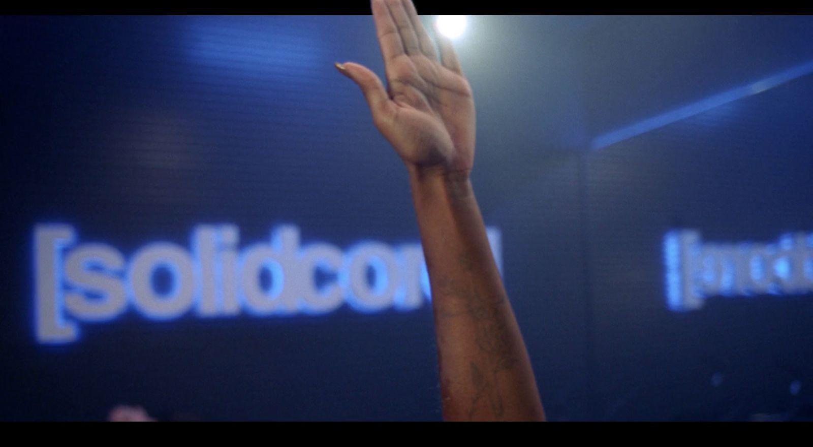 a person raising their hand up in front of a sign