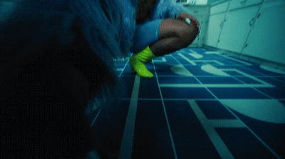 a woman in a blue coat and neon green boots