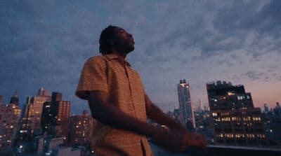 a man standing in front of a city skyline